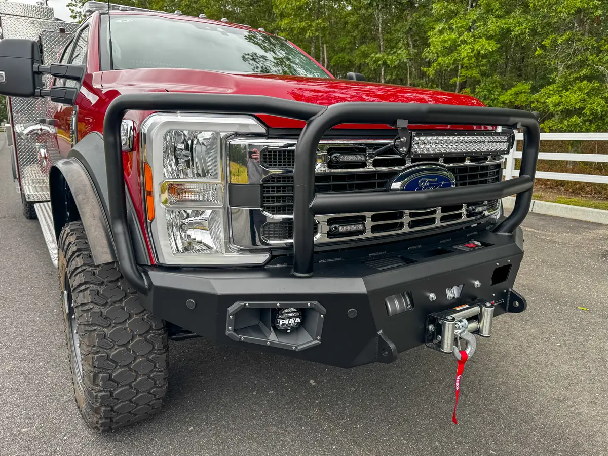 Front grille close-up showing emblem, grille slats, and mounted light bar.